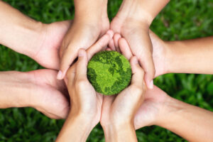 Hands holding the earth – demonstrating our first steps into sustainability