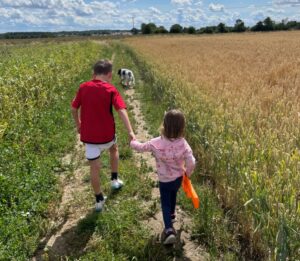 Biological son and adopted daughter going for a walk in the countryside with the family on a sunny day