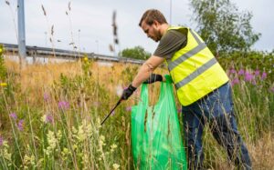 An employee litter picking, as part of a green marketing strategy